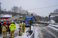 En gangbru over E16 har veltet etter at et kjøretøy kjørte inn i den. Det er store trafikale problemer,