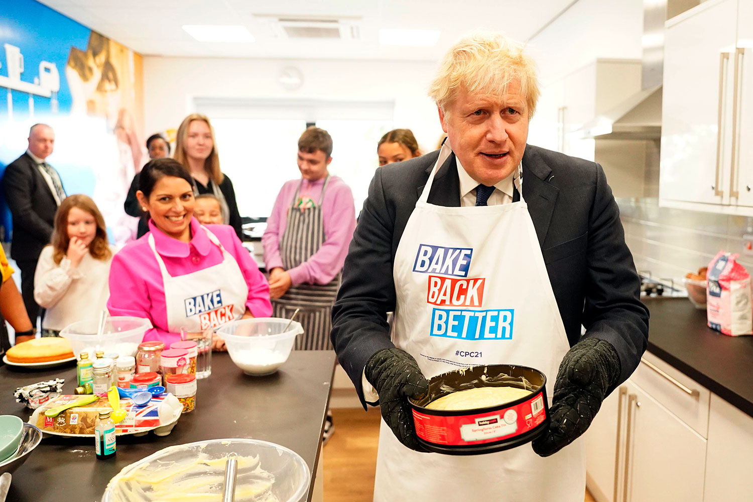 Storbritannias statsminister Boris Johnson og innenriksminister Priti Patel fikk teste bakekunstene da de besøkte et ungdomssenter før landsmøtet braket løs i Manchester søndag.